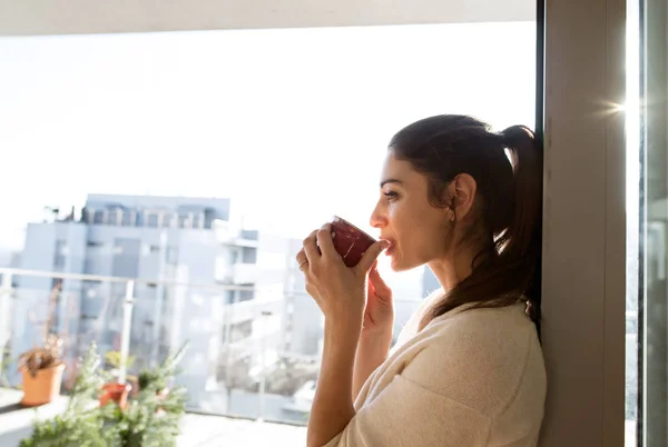 Žena uvolňující na balkon hospodářství šálek kávy nebo čaje — Stock fotografie