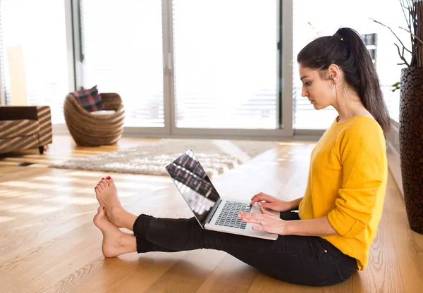 Vrouw op het huis zittend op de vloer, die werkt op laptop, schrijven — Stockfoto