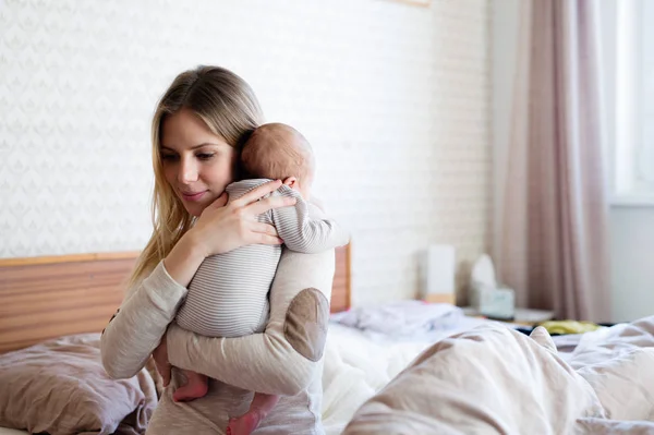 Hermosa madre joven sosteniendo al bebé en sus brazos — Foto de Stock