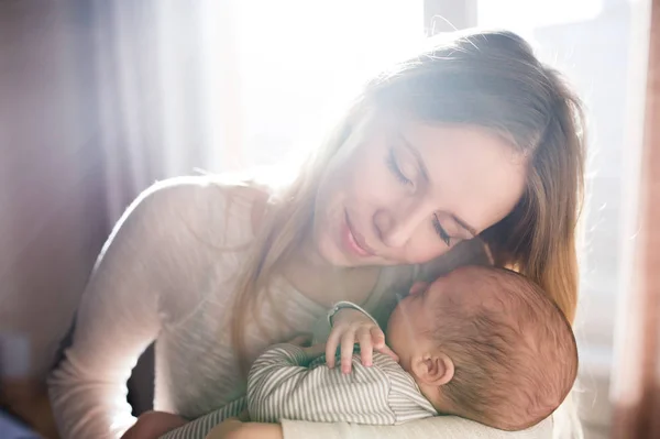 Belle jeune mère tenant bébé fils dans ses bras — Photo