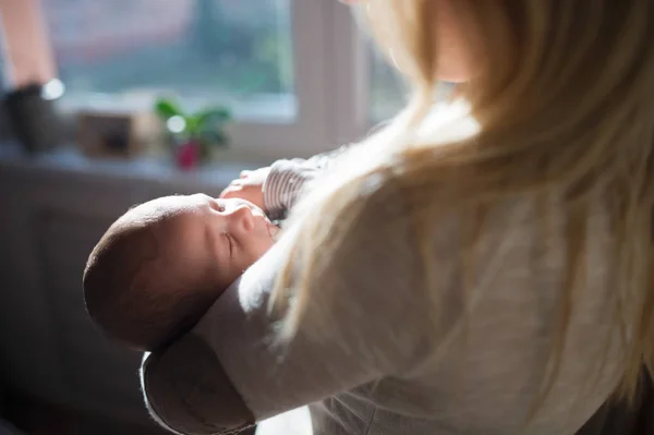 Junge Mutter mit Baby auf dem Arm nicht wiederzuerkennen — Stockfoto