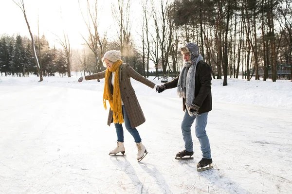 Senior paar in zonnige winter natuur schaatsen. — Stockfoto