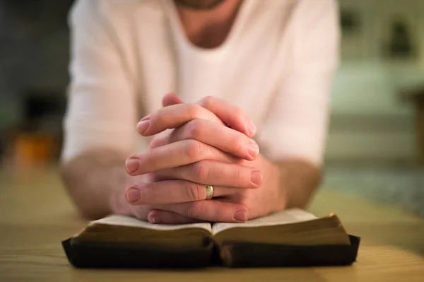 Unerkennbarer Mann betet, kniet auf dem Boden, Hände auf Bibel — Stockfoto