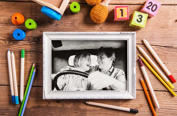 Foto em preto-e-branco de casal sênior em um carro em quadro branco — Fotografia de Stock