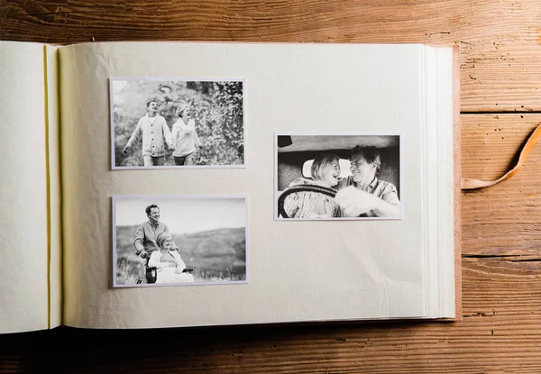 Photo album with black-and-white pictures of senior couple. — Stock Photo, Image