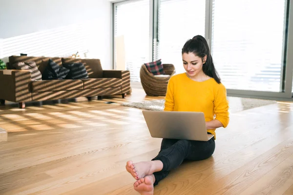 Frau zu Hause sitzt auf dem Boden, arbeitet am Laptop, schreibt — Stockfoto