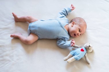 Oyuncak ayı yatakta yatarken şirin yeni doğan bebek çocuk