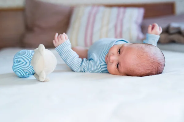 Lindo bebé recién nacido con oso de peluche acostado en la cama — Foto de Stock