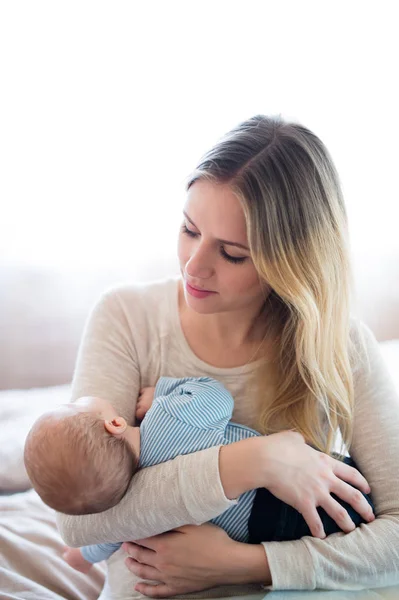 Güzel genç anne kucağında bebek evlat holding — Stok fotoğraf