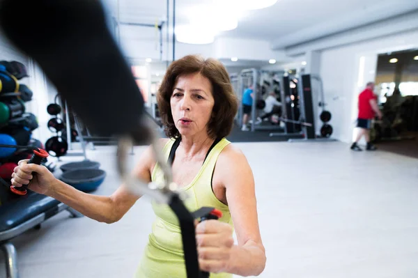 Donna anziana in palestra che lavora con i pesi . — Foto Stock