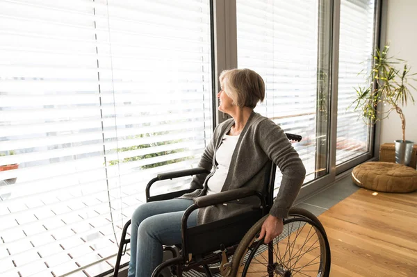 Disabled senior woman in wheelchair at home in living room. — Stock Photo, Image