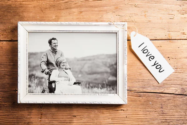 Foto von Senioren in Bilderrahmen auf Holzgrund gelegt. — Stockfoto