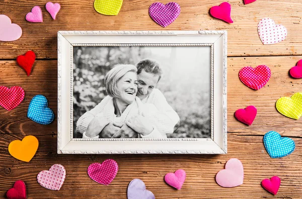 Foto de idosos no quadro de imagem colocada no fundo de madeira . — Fotografia de Stock