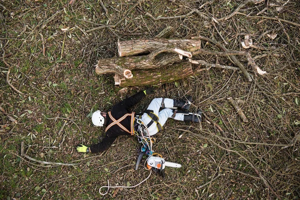 Taglialegna ferito con motosega sdraiato a terra dopo la caduta — Foto Stock