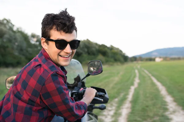 Ung man njuter en motorcykel rida på landsbygden. — Stockfoto