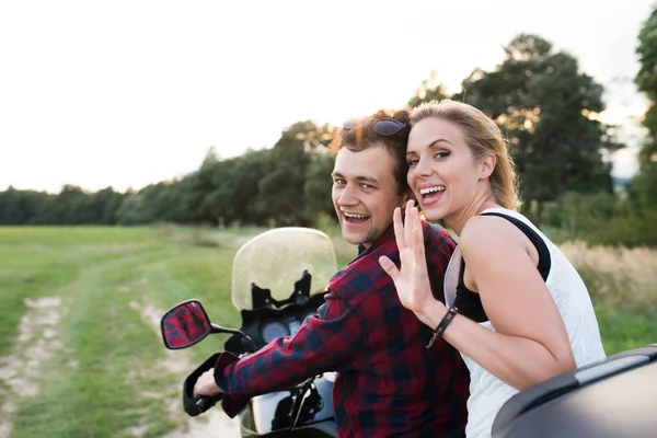Casal apaixonado desfrutando de um passeio de moto no campo . — Fotografia de Stock
