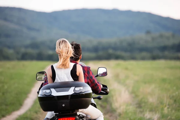 Casal apaixonado desfrutando de um passeio de moto no campo . — Fotografia de Stock