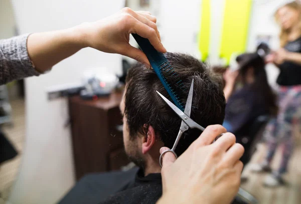 Parrucchiere irriconoscibile taglio capelli del suo giovane cliente . — Foto Stock