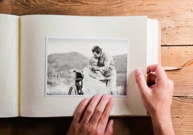 Üst düzey iki resim ile fotoğraf albümü holding eller. Stüdyo