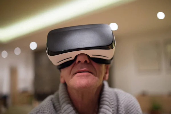 Senior trägt Virtual-Reality-Brille zu Hause — Stockfoto