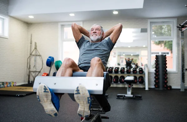 Passar äldre mannen i gymmet arbetar hans abs, gör crunches. — Stockfoto