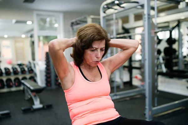 Schön fitte Seniorin, die ihren Bauch bearbeitet und Crunches macht. — Stockfoto