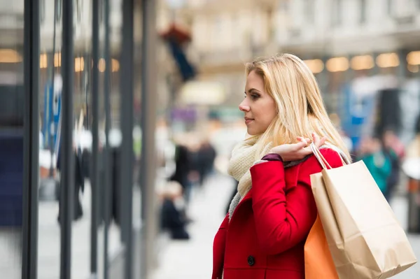 Kobieta w oknie zakupy w centrum miasta. Zimowe — Zdjęcie stockowe