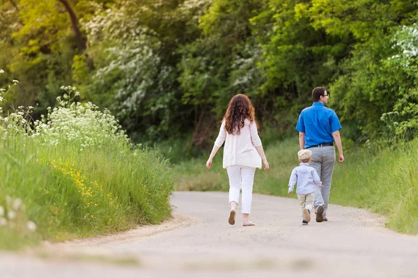Yeşil doğa ülkede yol üzerinde yürüyen genç aile — Stok fotoğraf