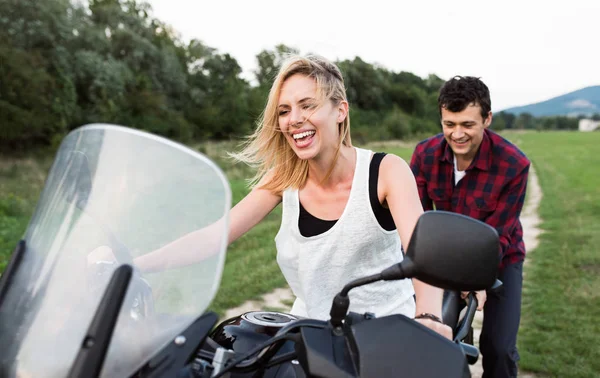 Pár élvezi a motorkerékpár szerelmes lovagolni vidéken. — Stock Fotó