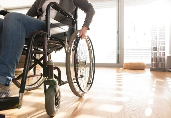 Mulher idosa deficiente irreconhecível em cadeira de rodas em casa . — Fotografia de Stock