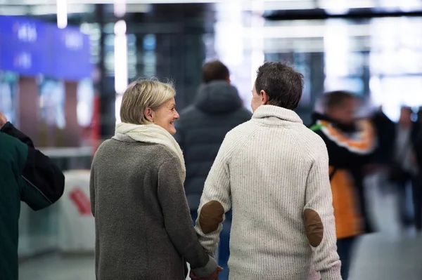 Seniorenpaar im Flur der U-Bahn, Händchen haltend. Rückansicht. — Stockfoto