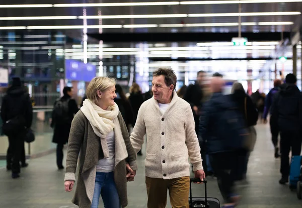 Pareja mayor en el pasillo del metro tirando del equipaje del carro . —  Fotos de Stock