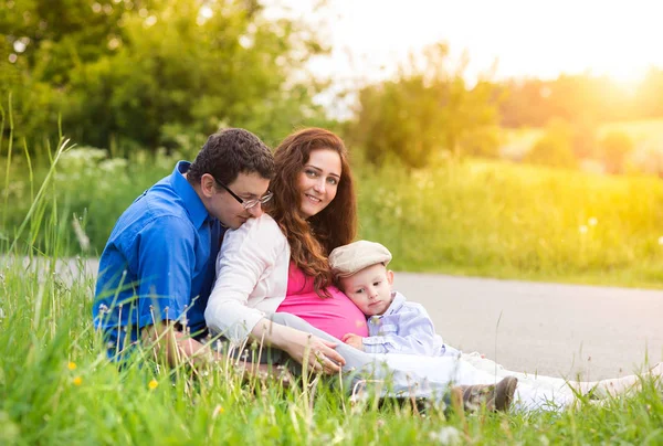 Young family on a walk in green sunny summer nature — Stock Photo, Image