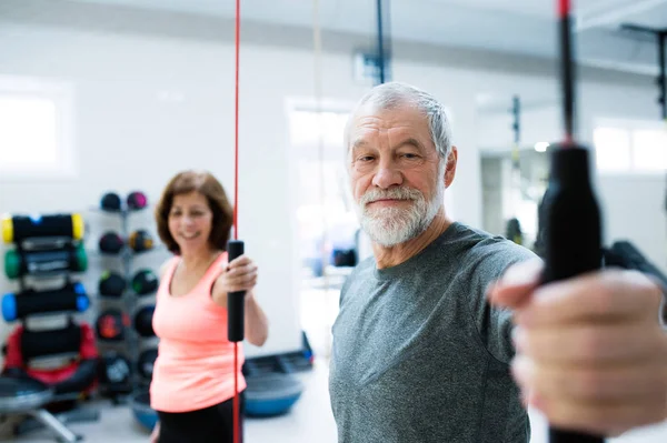 Äldre par i gymmet träna med vibrationer barer — Stockfoto