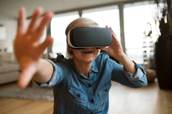 Mujer mayor con gafas de realidad virtual en casa — Foto de Stock