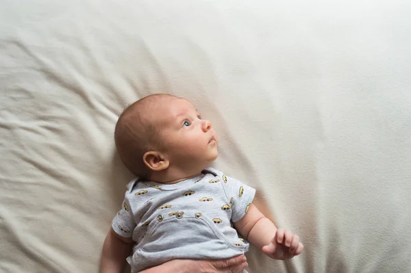 Bonito menino recém-nascido deitado na cama, close-up — Fotografia de Stock