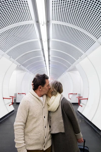 年长的夫妇在走廊的地铁拉手推车行李. — 图库照片