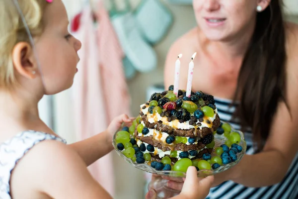 Onun sevimli doğum günü pastası mumlar ile veren anne — Stok fotoğraf