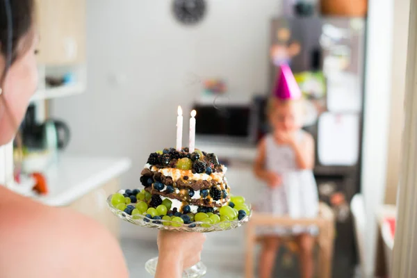 Onherkenbaar moeder dochter verjaardag cake met kaarsen geven — Stockfoto