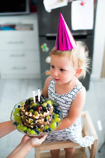 K nepoznání matka dává dcery narozeninový dort se svíčkami — Stock fotografie