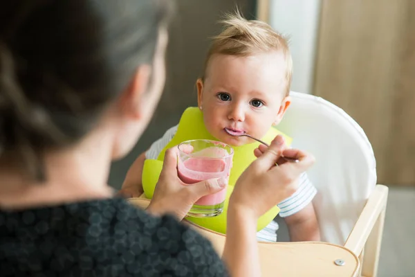 Madre irreconocible alimentando a su hija bebé con yogur —  Fotos de Stock