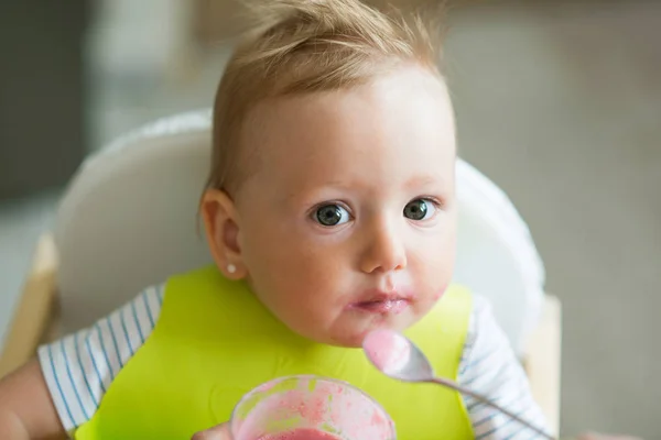 Oigenkännlig mamma mata dottern baby med yoghurt — Stockfoto