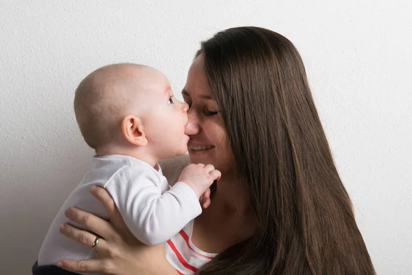 Beautiful mother holding baby son in her arms. Studio shot. — Stock Photo, Image