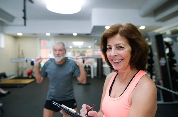 Hombre mayor en el gimnasio haciendo ejercicio con pesas — Foto de Stock