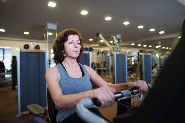 Vacker passform senior kvinna i gymmet gör hjärt arbete. — Stockfoto