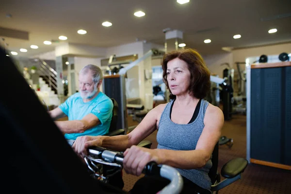 Beau couple de personnes âgées en forme dans la salle de gym faire du cardio-training . — Photo