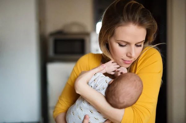 Belle jeune mère tenant bébé fils dans ses bras — Photo