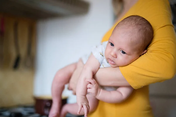 Méconnaissable jeune mère tenant bébé fils dans ses bras — Photo