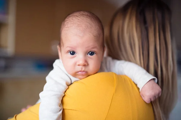 Beautiful young mother holding baby son in her arms — Stock Photo, Image