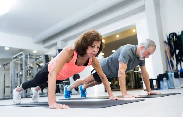 Äldre par i gymmet träna, göra push ups — Stockfoto